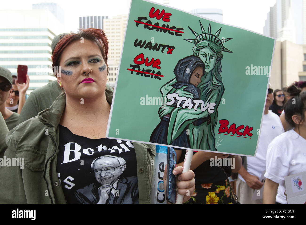 Dallas, Texas, USA. 30th June, 2018. A demonstrator listens to speakers in front of Dallas City Hall in downtown Dallas. People congregated to protest the Trump policy of separating immigrant children from their parents when they crosss the US/Mexico border seeking asylum in this country. Credit: Jaime R. Carrero/ZUMA Wire/Alamy Live News Stock Photo