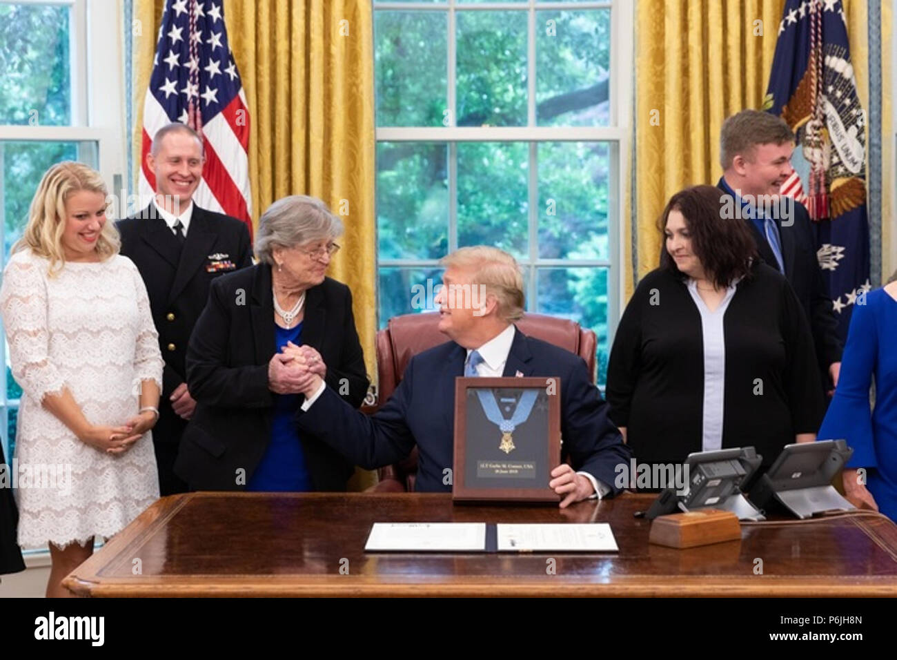 WASHINGTON, DC - WEEK OF JUNE 24: President Donald J. Trump welcomes Mrs. Pauline Conner, the widow of Medal of Honor recipient, the late U.S. Army 1st Lt. Garlin Murl Conner, and family members to the Oval Office on Tuesday, June 26, 2018, at the White House  People:  President Donald Trump Stock Photo