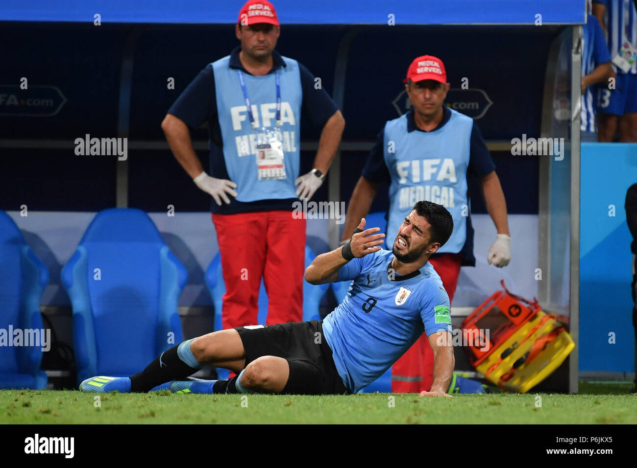 Sochi, Russland. 30th June, 2018. Luis SUAREZ (URU) lies theatrically on the ground and simulates an injury-standing behind him are paramedics. Uruguay (URU) - Portugal (POR) 2-1, Round of 16, Round of 16, Game 49, on 30.06.2018 in SOCHI, Fisht Olympic Stadium. Football World Cup 2018 in Russia from 14.06. - 15.07.2018. | usage worldwide Credit: dpa/Alamy Live News Stock Photo