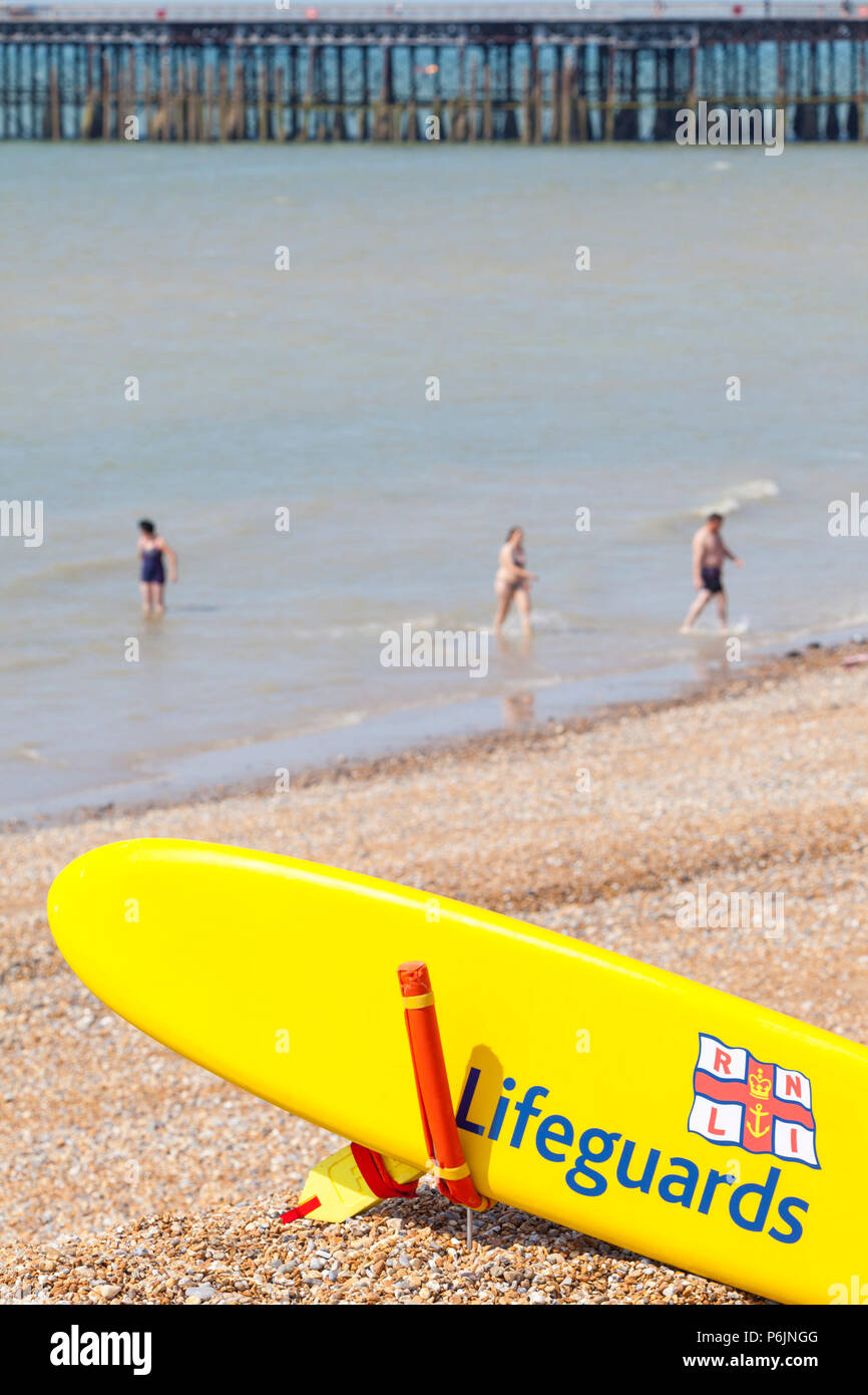 Hastings, East Sussex, UK. 1st Jul, 2018. UK Weather: The heatwave continues in Hastings with temperatures expected to exceed 24°C. Plenty of people are out and about walking along the seafront as the tide is out at the moment. Lifeguard paddle boards at the ready. Photo Credit: Paul Lawrenson / Alamy Live News Stock Photo
