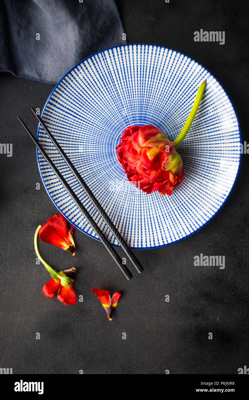 Summer table setting decorated with Red Princess tulips on rustic background Stock Photo