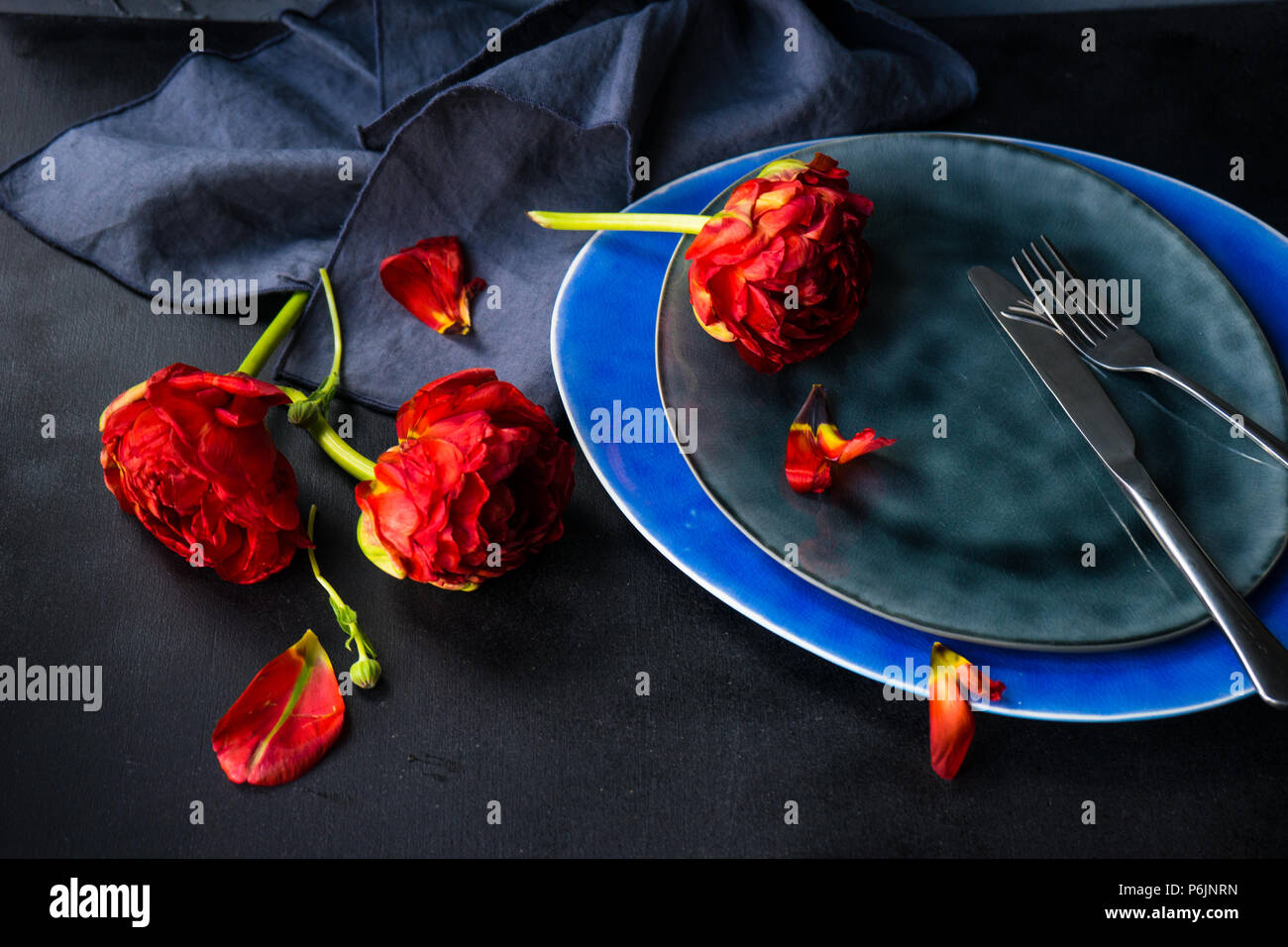 Summer table setting decorated with Red Princess tulips on rustic background Stock Photo