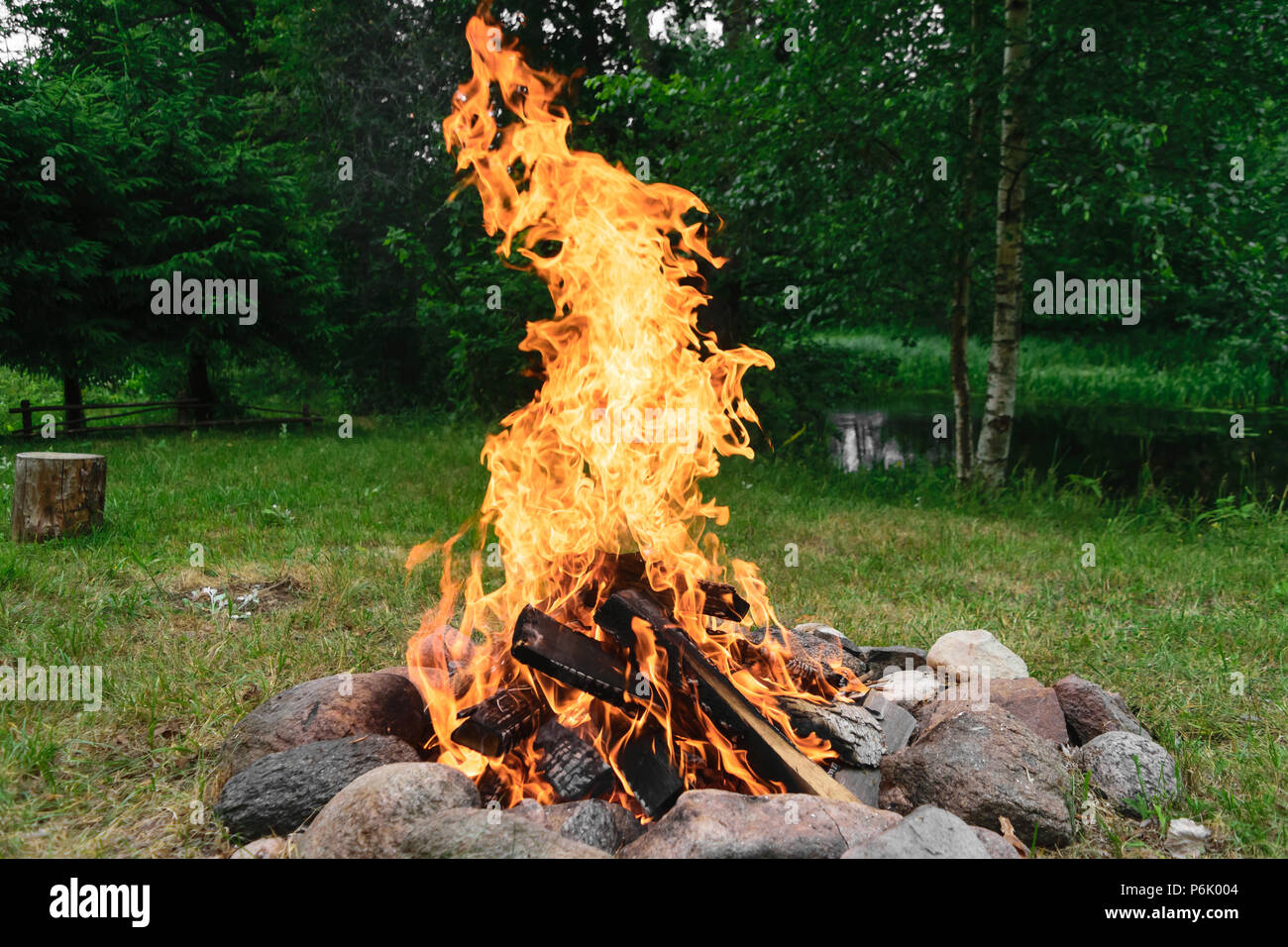 Burning bonfire with in round fireplace from stones in the nature Stock