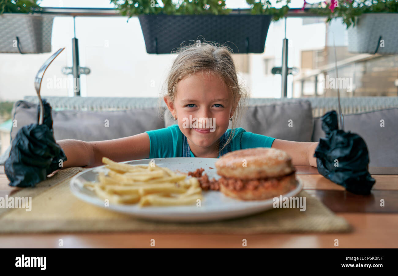 child eats a Burger in a restaurant Stock Photo