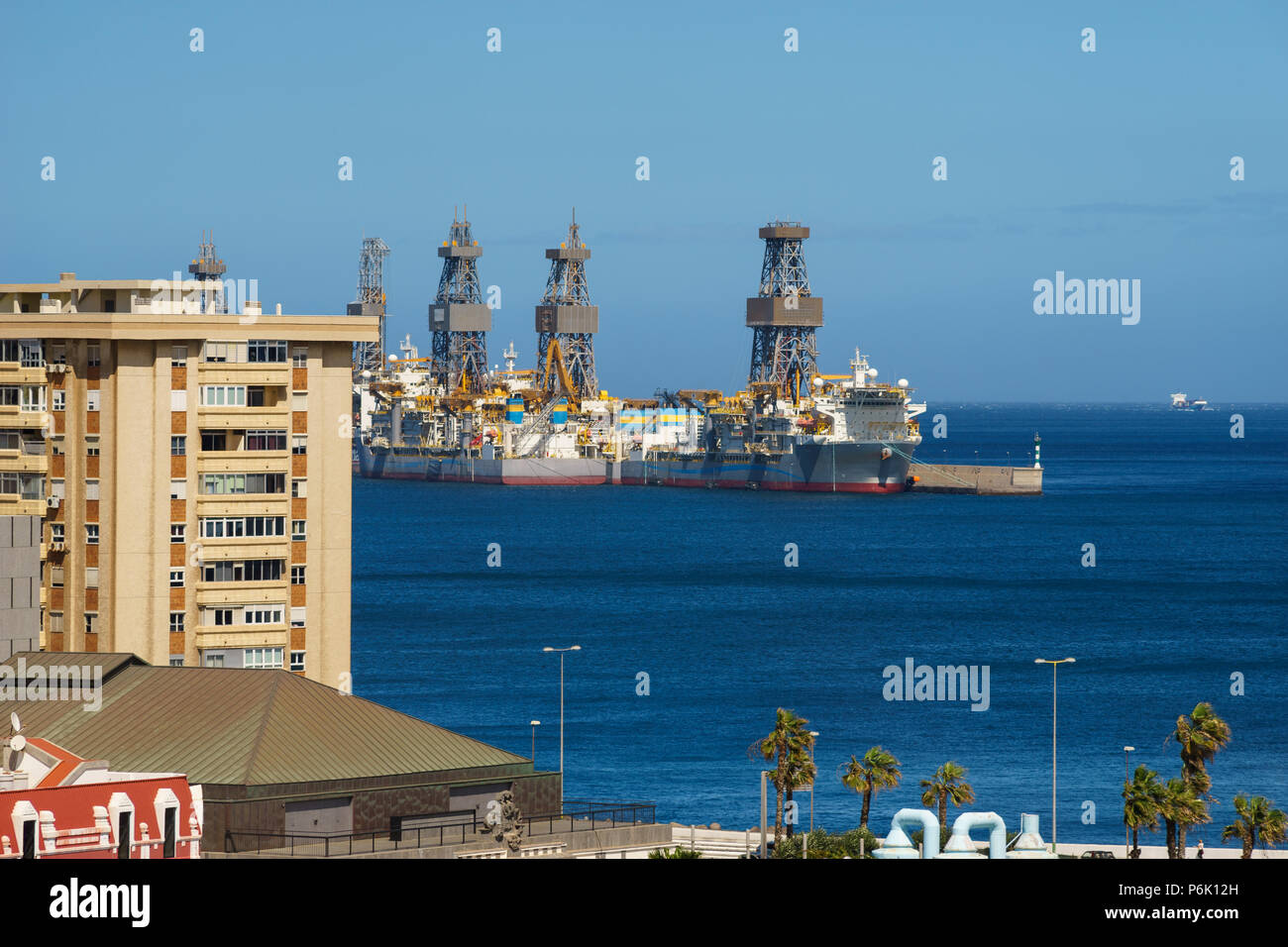 Drillships near coastal city. Oil and gas offshore drilling Stock Photo