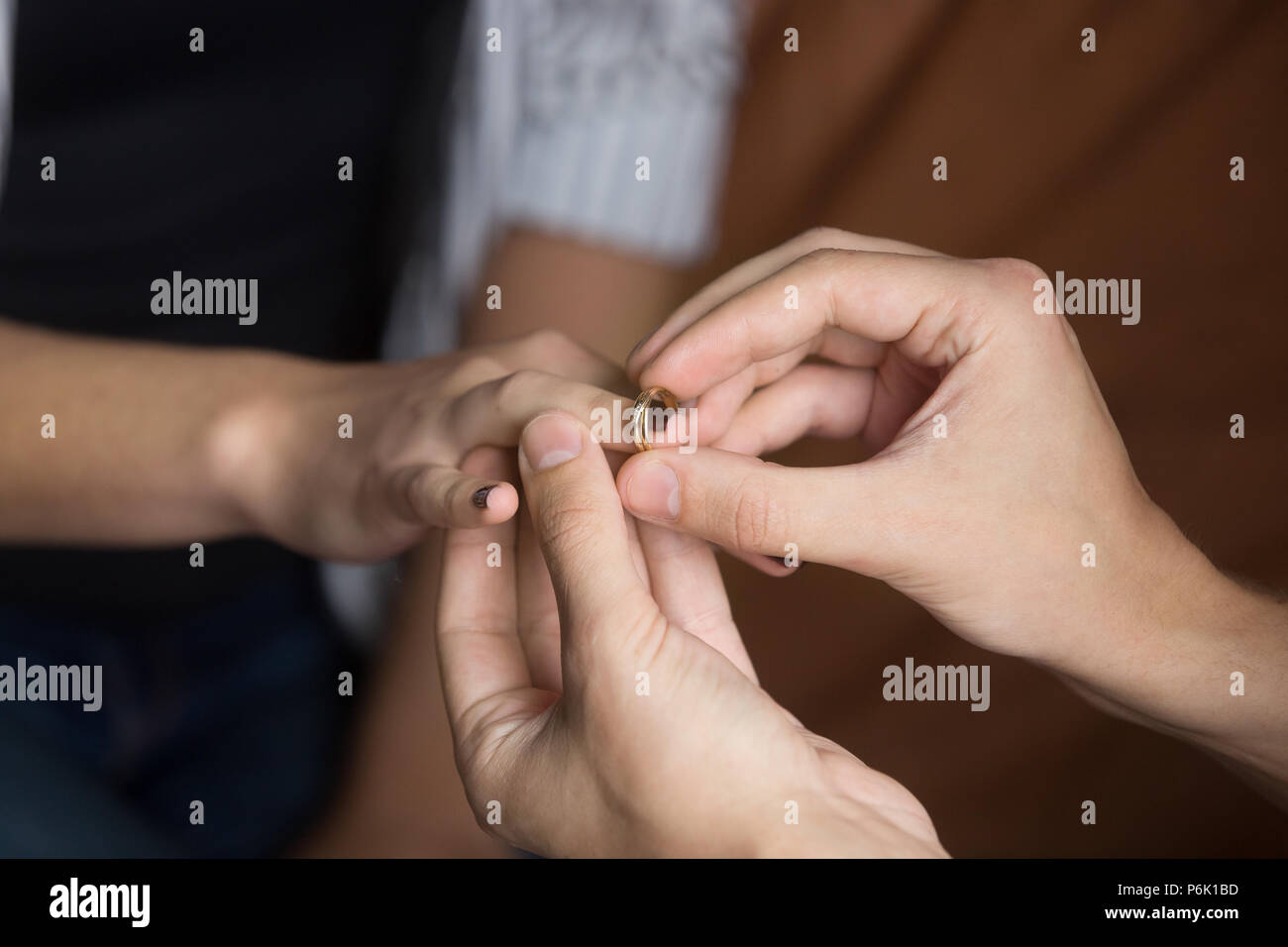 Close up of man putting wedding ring on woman finger Stock Photo