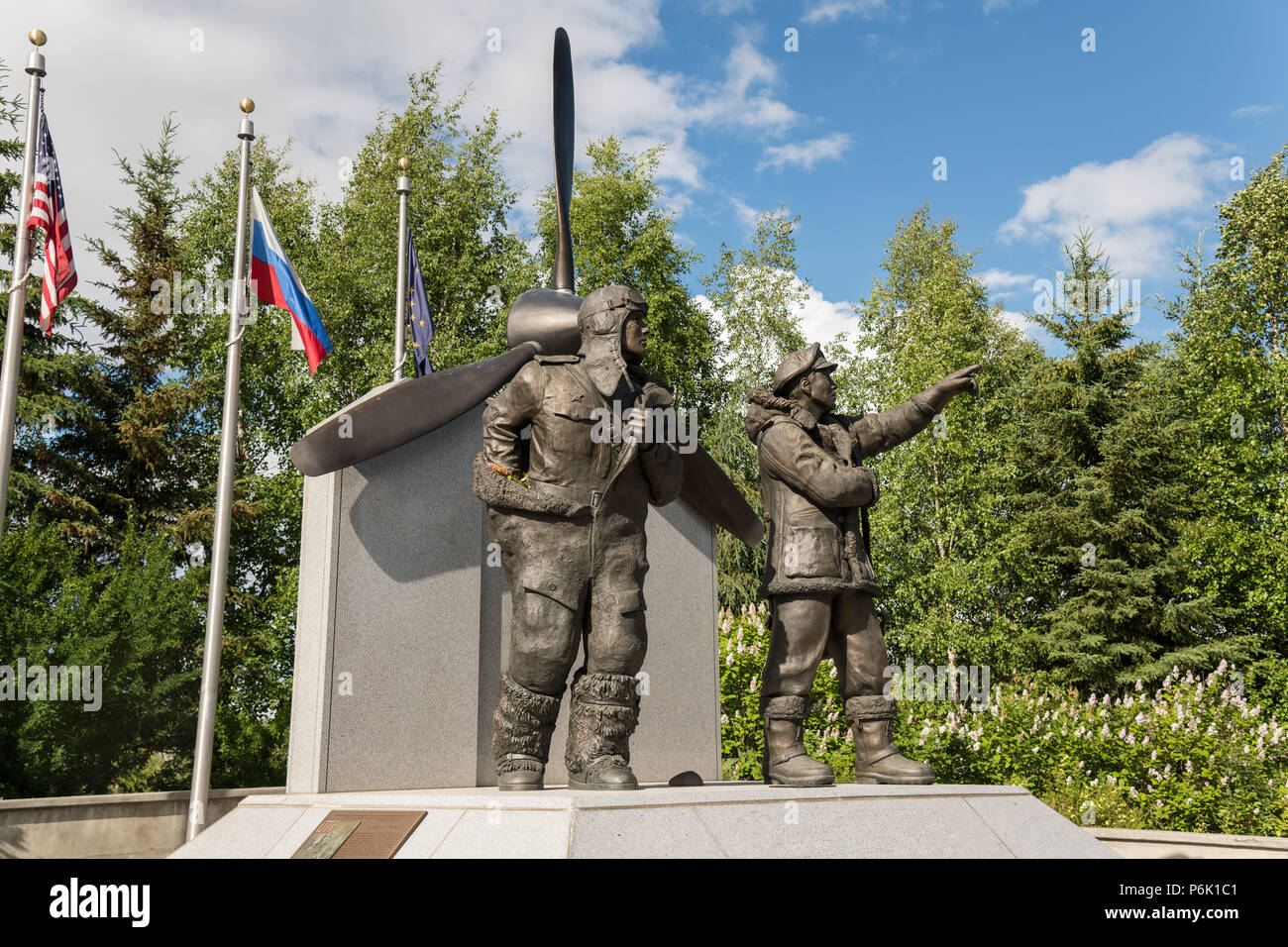 A tourist views the Lend Lease Monument in downtown riverfront park in Fairbanks, Alaska. The statue depicts Russian and American WWII pilots, commemorating Alaska as the staging ground in the Lend-Lease program which provided nearly 8,000 aircraft to the eastern front. Stock Photo