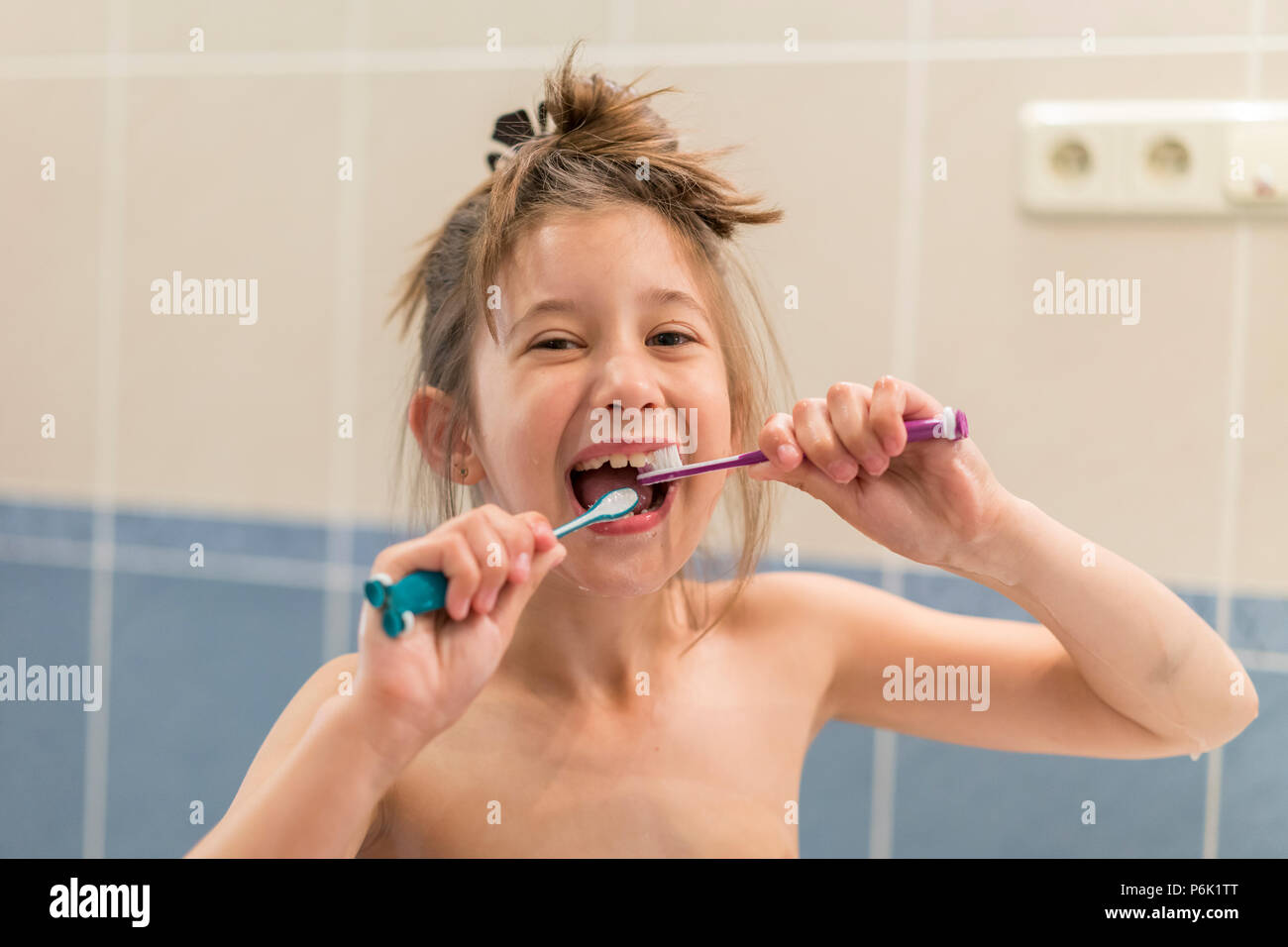 Little girl brushes teeth with two brushes. Stomatology. oral health