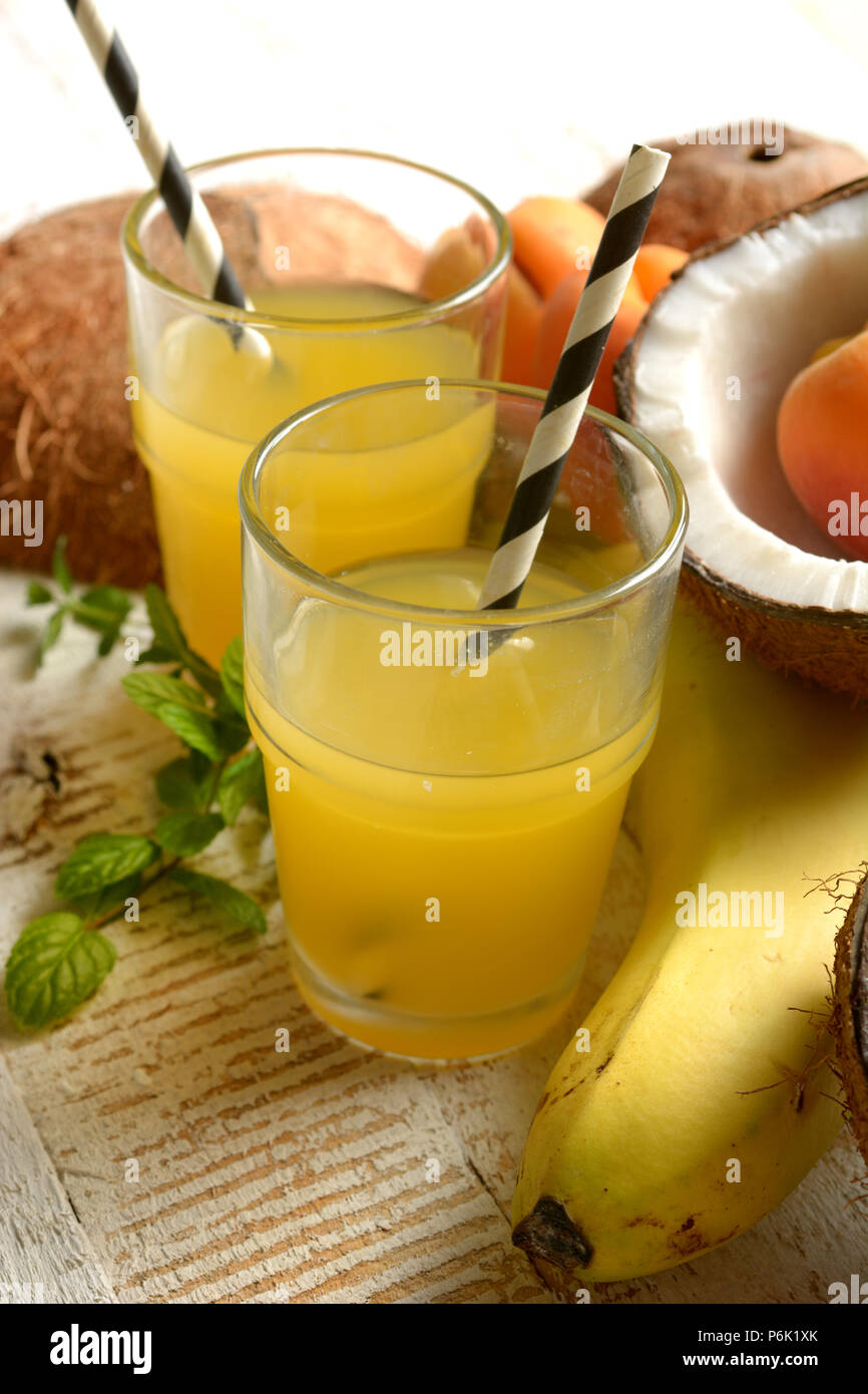 tropical fruits drink with around coconut, bananas and apricots