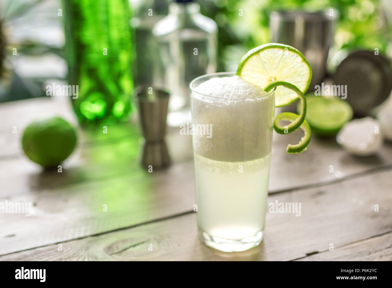 Egg Gin Fizz Cocktail with Lime Garnish. Making Gin Fizz Drink with