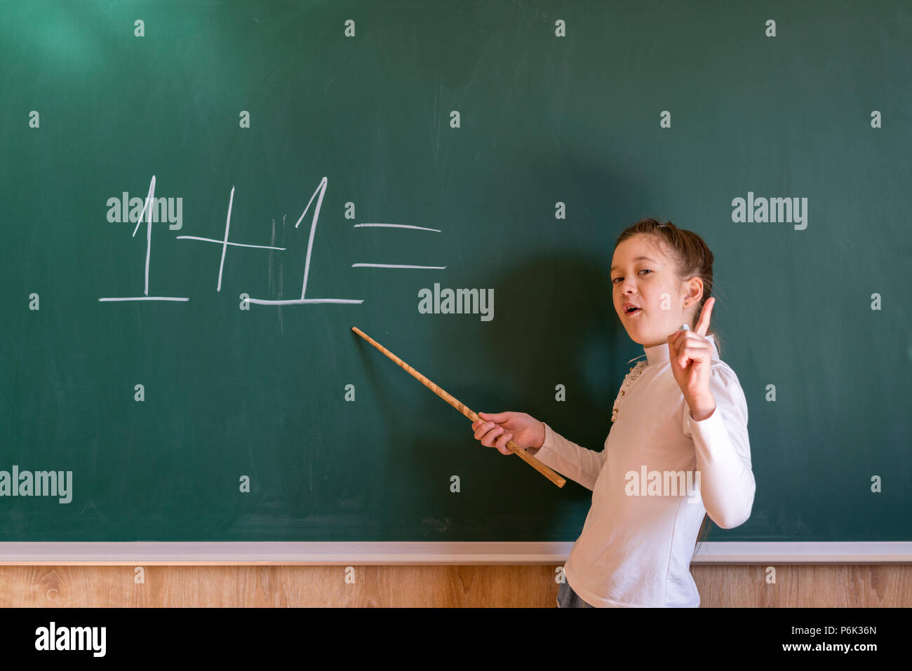 The child can not solve the problem in the school near the board. A hard day at school. Stock Photo