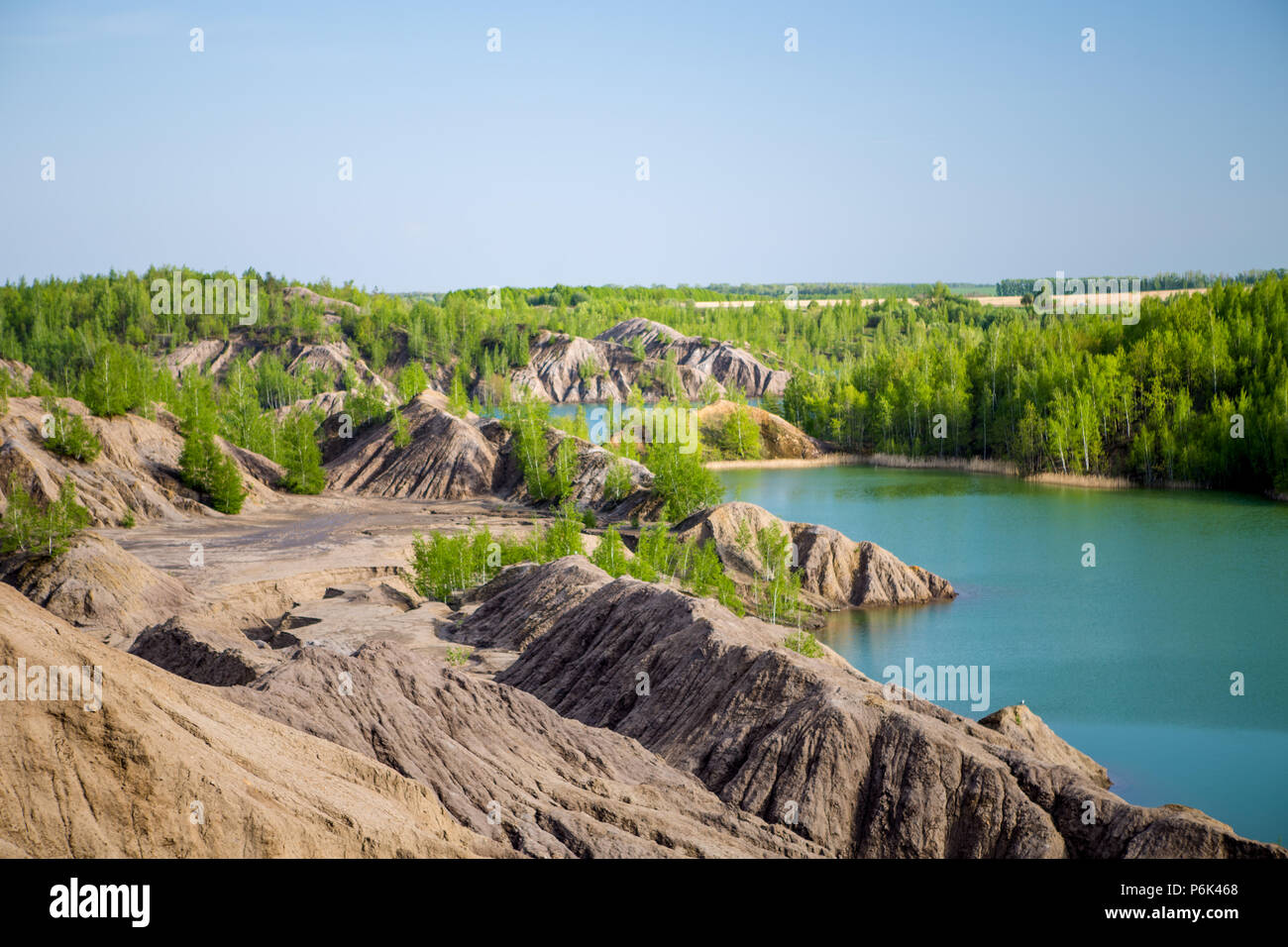 Photo of picturesque hilly area with vegetation and blue lake Stock Photo