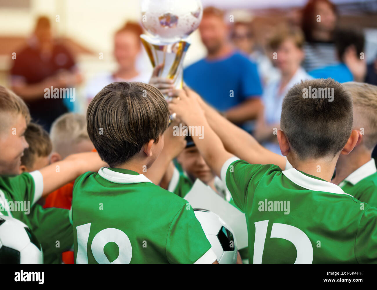 Kids Raising Golden Cup for Winning Sports Team. Children in Green Sportswear Celebrating Sport Success. Happy Kids Celebrate the Victory Stock Photo