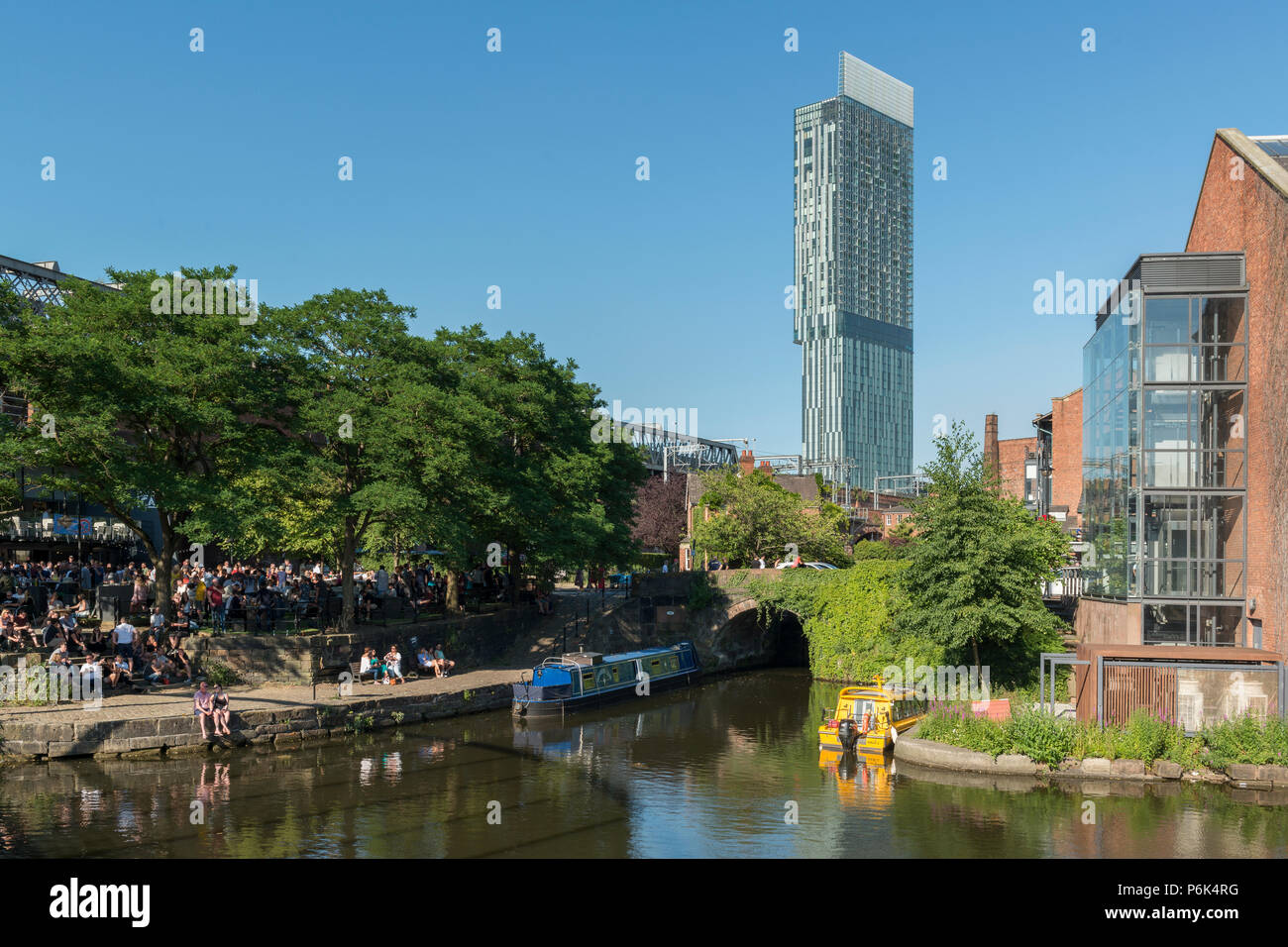 A general view of the Castlefield area of Manchester featuring people socialising on a warm summer's day. Stock Photo