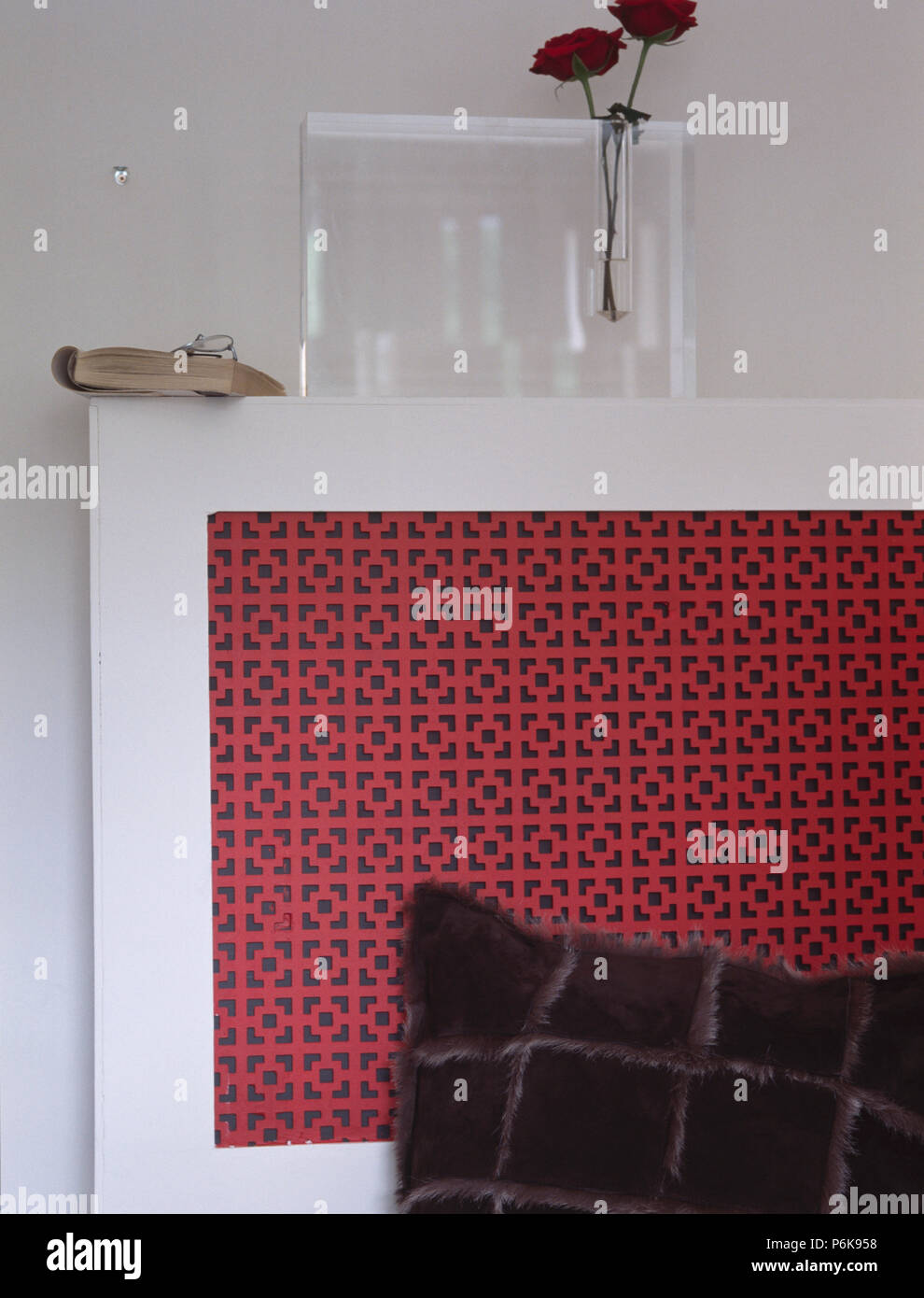 Oblong Glass Vase On White Radiator Cover With Red Fretwork Panel
