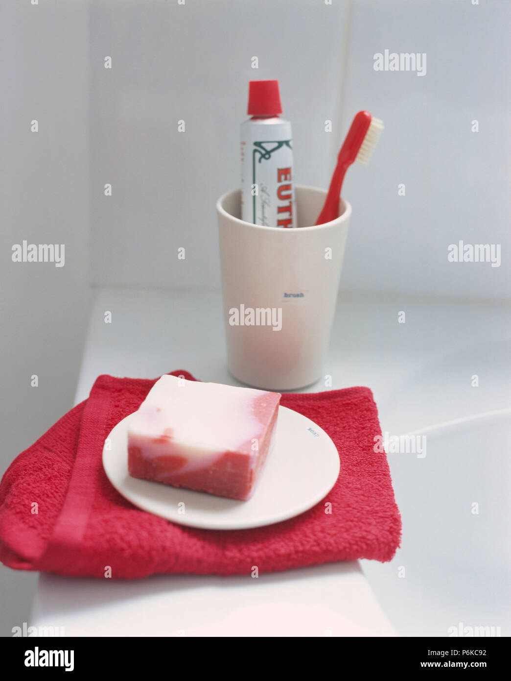 Closeup of bar of homemade soap on red flannel beside toothpaste and