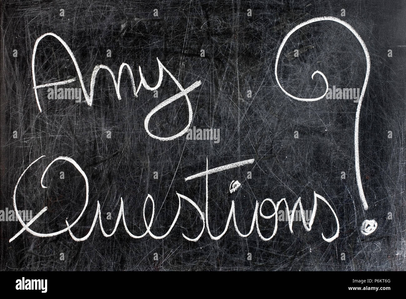 Any questions question handwritten with white chalk on dirty blackboard Stock Photo