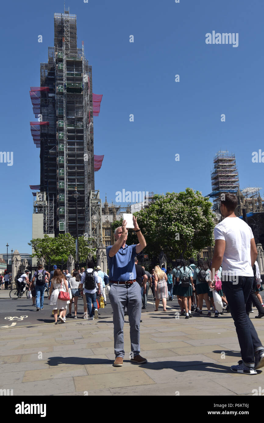 Tourists and visitors to London take photographs with smart mobile phones, ipads and tablets in Westminster outside the Houses of Parliament where Big Stock Photo