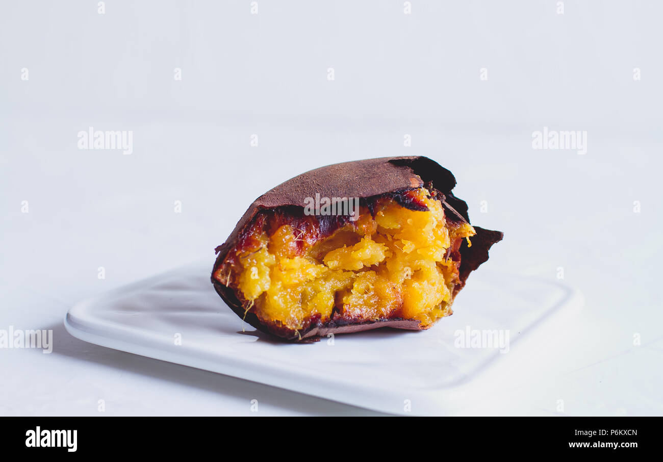 Roasted Japanese Sweet Potato in white background, texture, half eaten Stock Photo