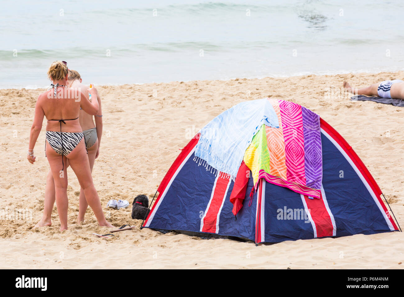 Bournemouth, Dorset, UK. 1st July 2018. UK weather: hazy sunshine, but still warm as thousands of sunseekers head to the beaches at Bournemouth to enjoy a day at the seaside. topping up the suntan lotion cream! Credit: Carolyn Jenkins/Alamy Live News Stock Photo