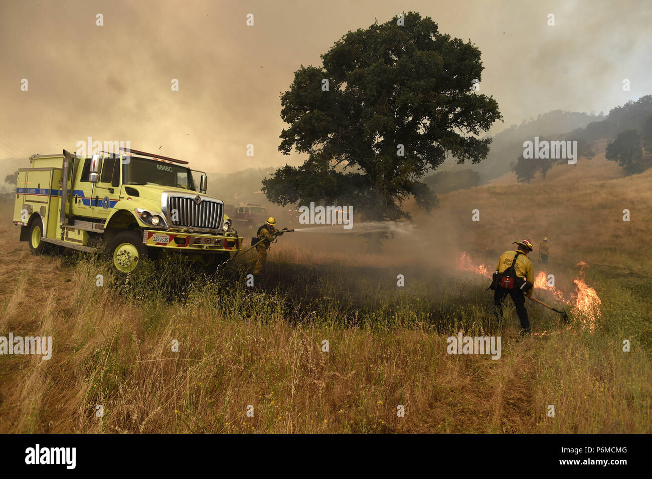 Clearlake Oaks, California, USA. 1st July, 2018. Fire crews worked quickly put out the many spot fires along highway 20 across from the main Pawnee Fire in Lake County. Credit: Neal Waters/ZUMA Wire/Alamy Live News Stock Photo