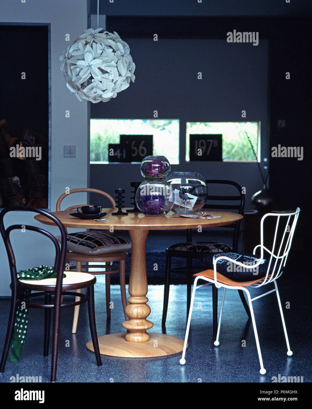 Bentwood chairs and white metal chair at circular wood table in modern