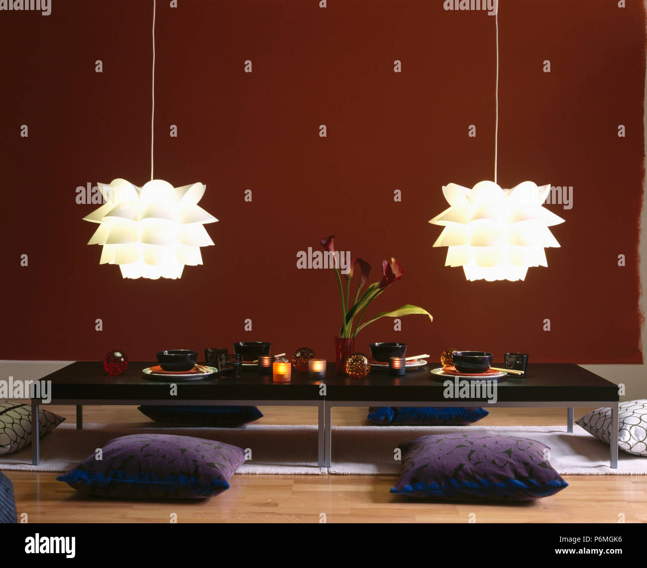 White Folded Plastic Ceiling Lights Above Grey Floor Cushions And Low Table Set For A Chinese Meal In Modern Dining Room Stock Photo Alamy