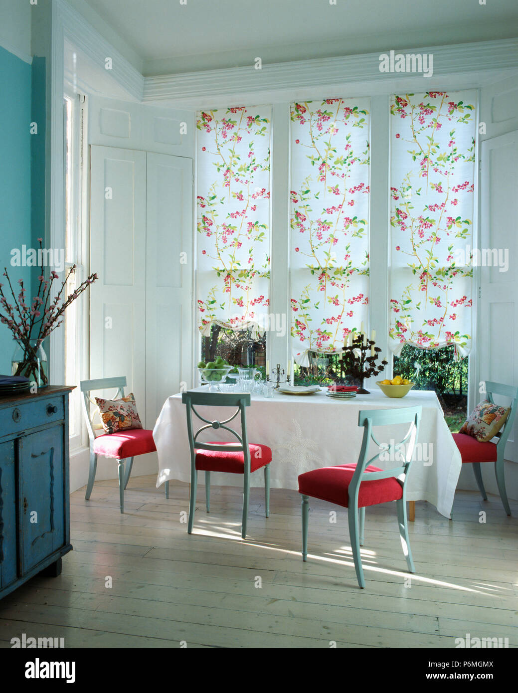 Floral Blind On Large Window In Dining Room With Wooden Flooring And Red Seated Chairs At Table With Crisp White Cloth Stock Photo Alamy