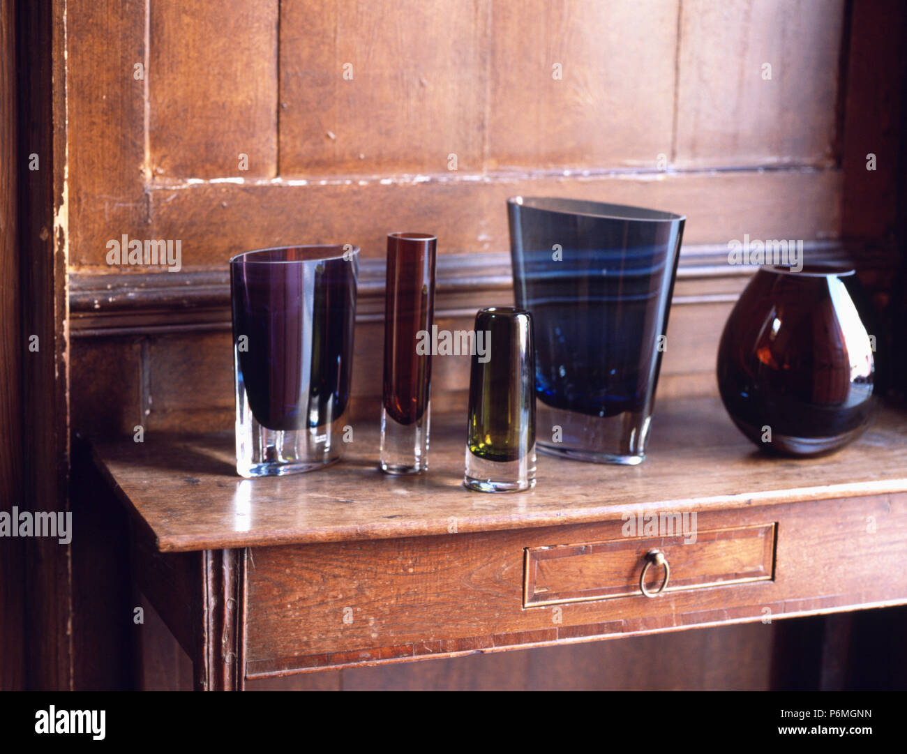 Close-up of nineties LSA dark glass vases on antique table Stock Photo