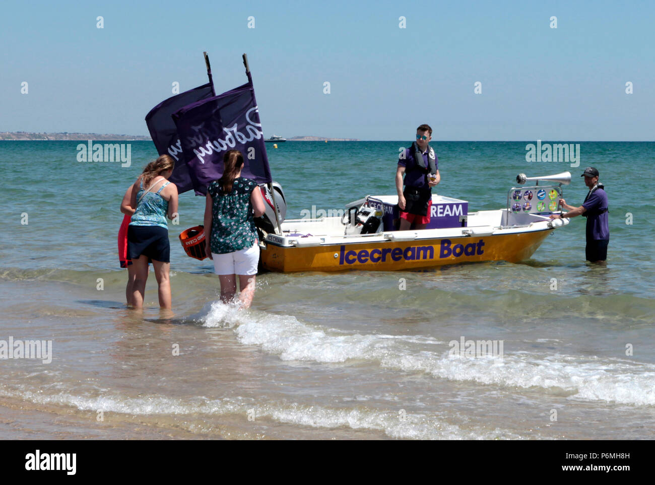 an Ice cream boat sells icecream to tourists in very warm weather June