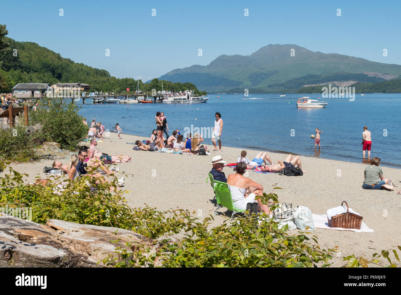 Luss beach, Loch Lomond and Ben Lomond busy on a hot summer day, Scotland, UK Stock Photo