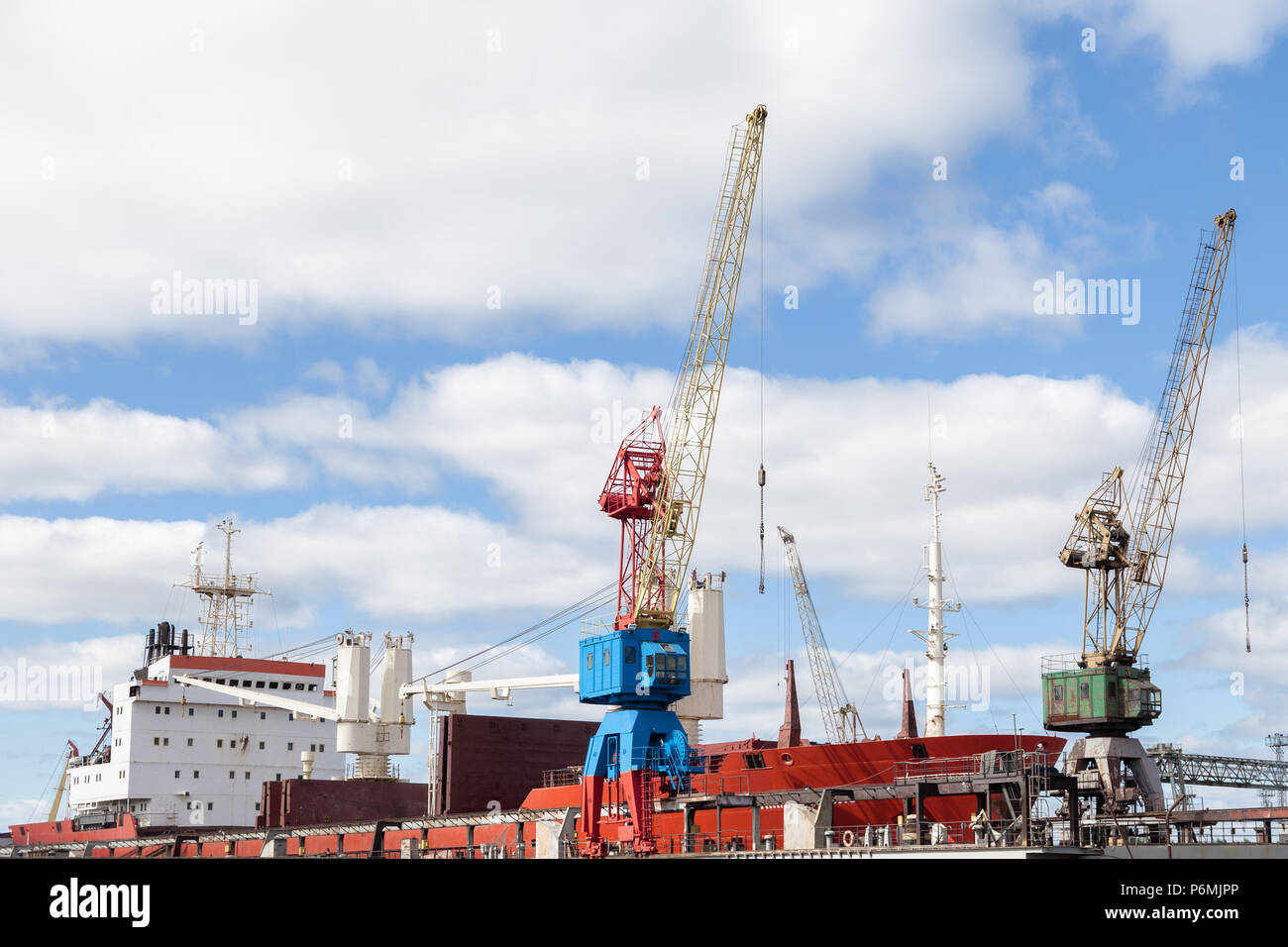 Port crane against a cloudy sky background Stock Photo