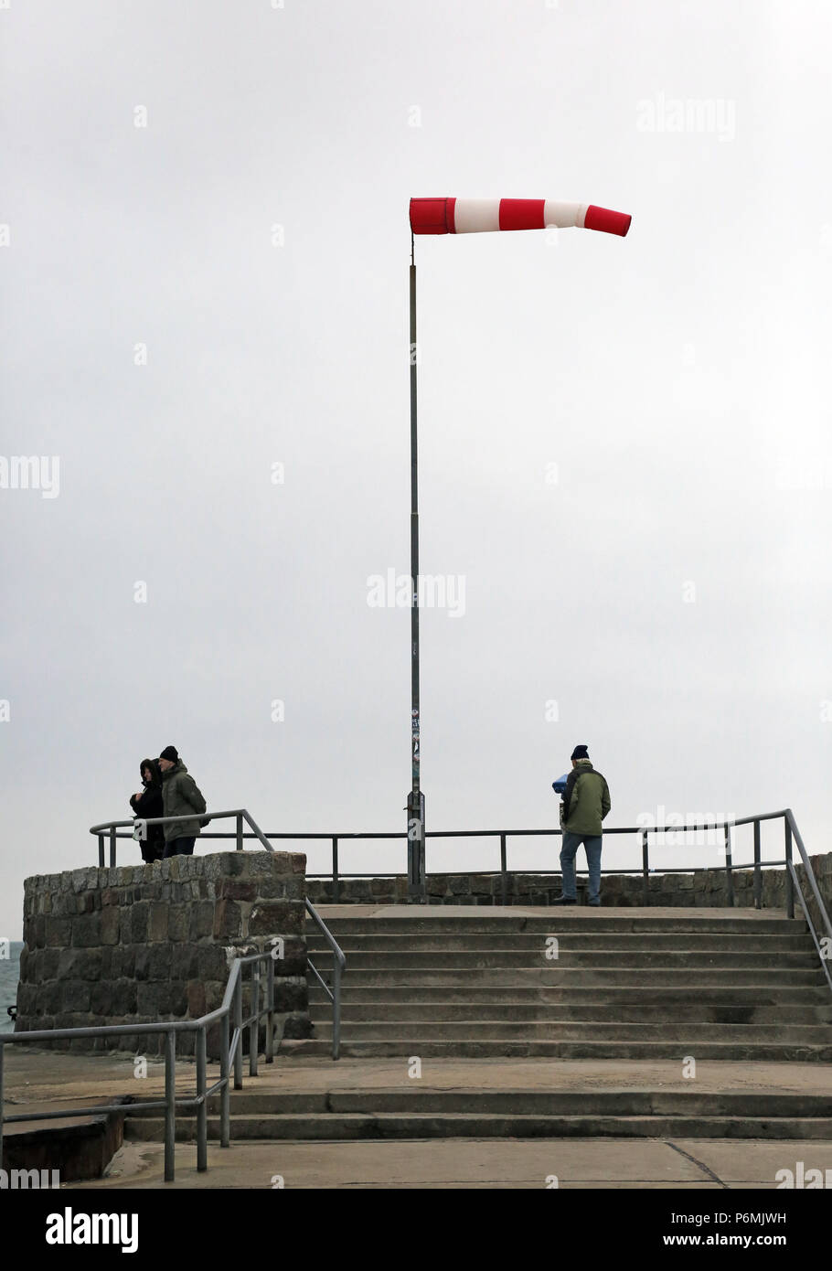 Warnemuende, people in strong wind on the Westmole Stock Photo