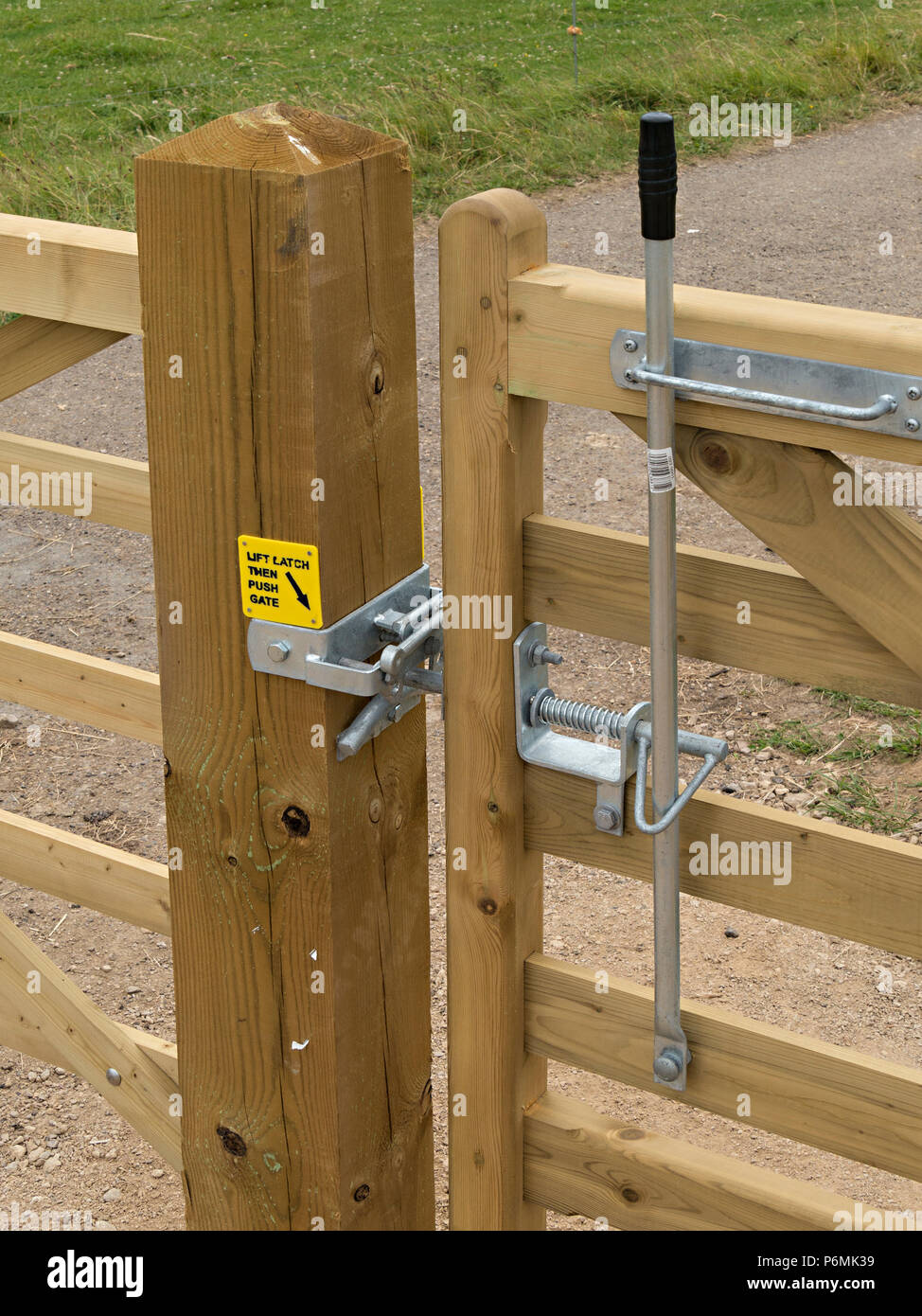 New galvanised metal bridle gate latch furniture fittings on wooden gate on horse bridleway, Derbyshire, UK Stock Photo