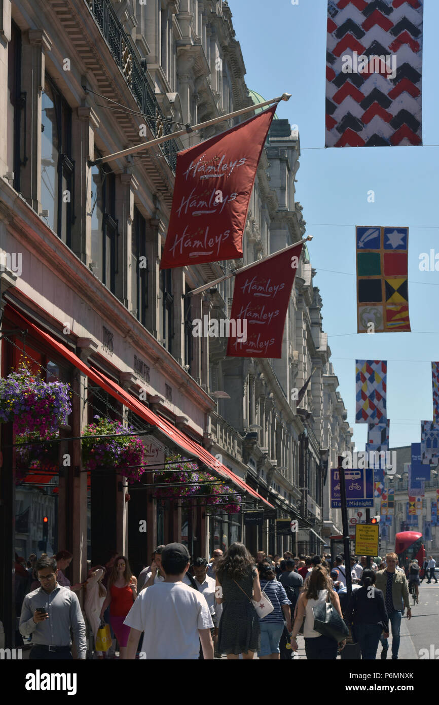 Shoppers, tourists and office workers walk past the flagship Hamleys toy store on Regent Street in central London in the summer sunshine. Stock Photo