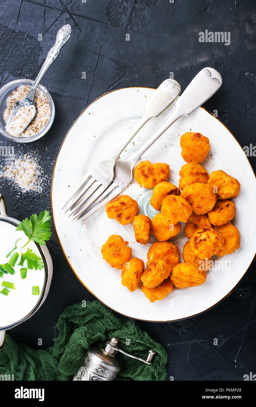 Fried breadcrumb covered chicken popcorn on plate with sauce Stock Photo Alamy