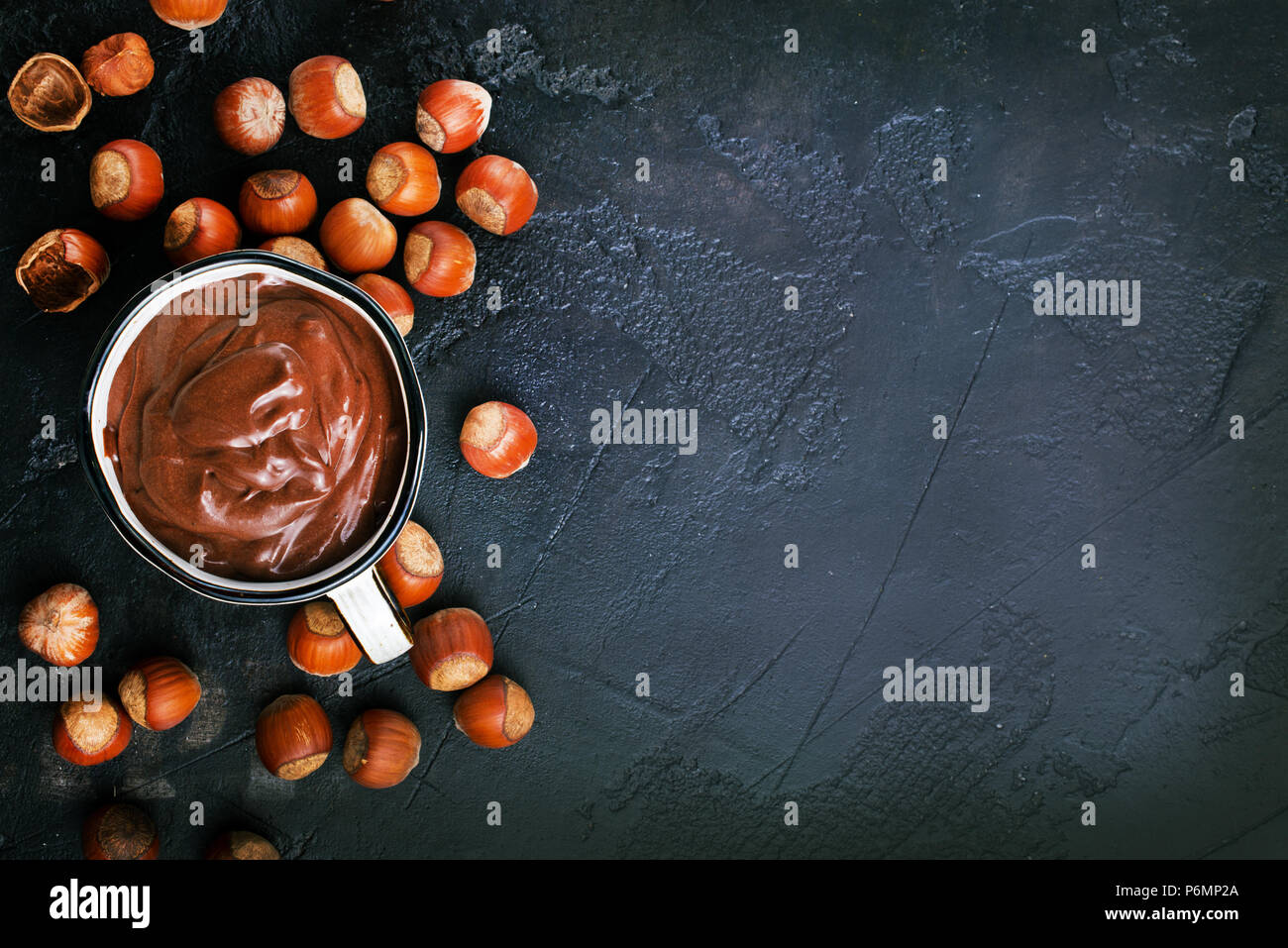 Homemade hazelnut spread or hot chocolate in cup with nuts and