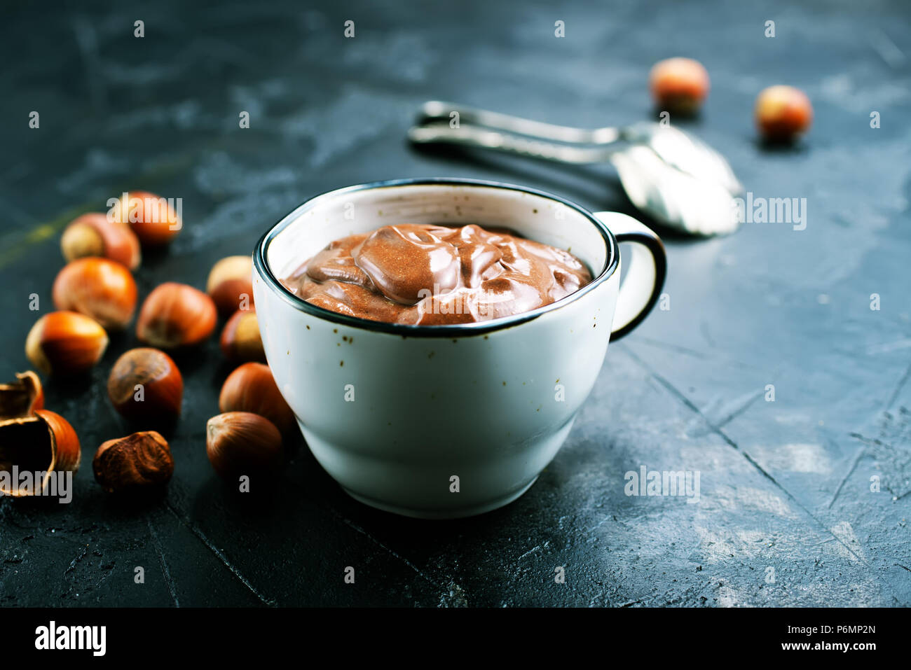 Homemade hazelnut spread or hot chocolate in cup with nuts and