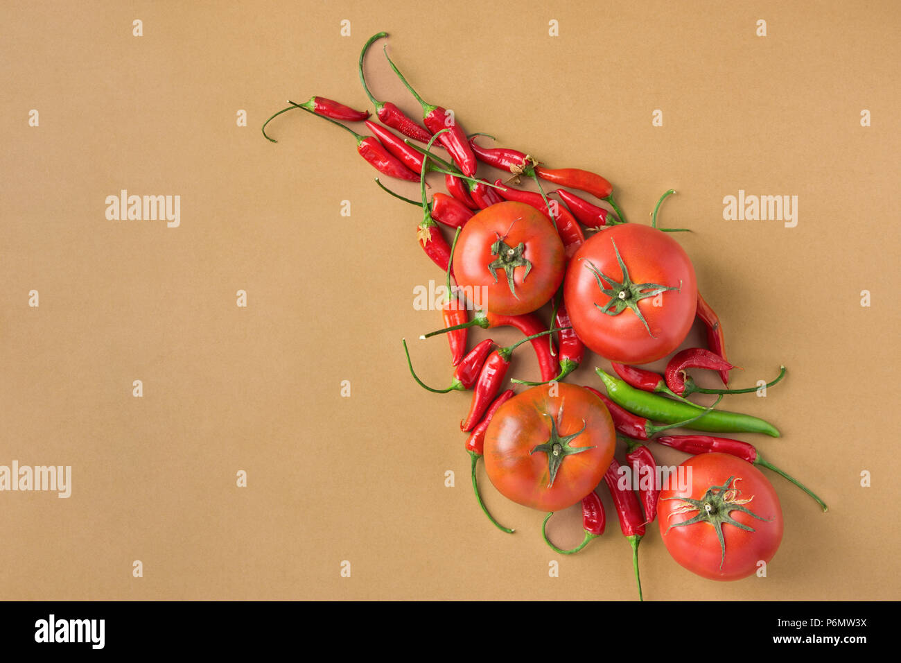 Fresh Ripe Organic Red Tomatoes Hot Chili Peppers Arranged on Brown Background. Mexican Italian Spanish Greek Mediterranean Cuisine. Healthy Diet Food Stock Photo