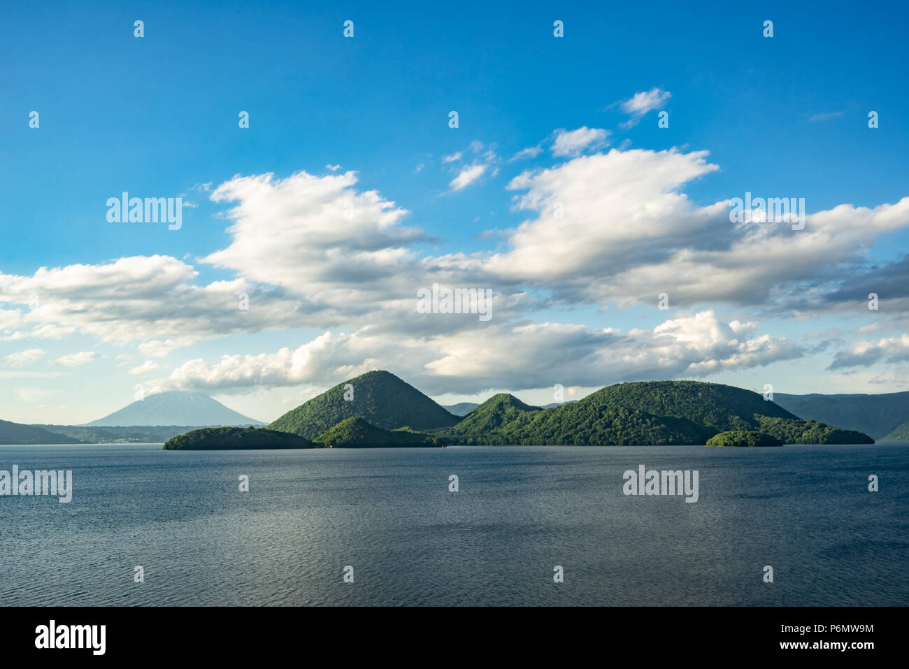 Nakajima island and Mount Yotei were seen from the shore of Lake Toya after a rainy cloudy day in June, 2018. Stock Photo
