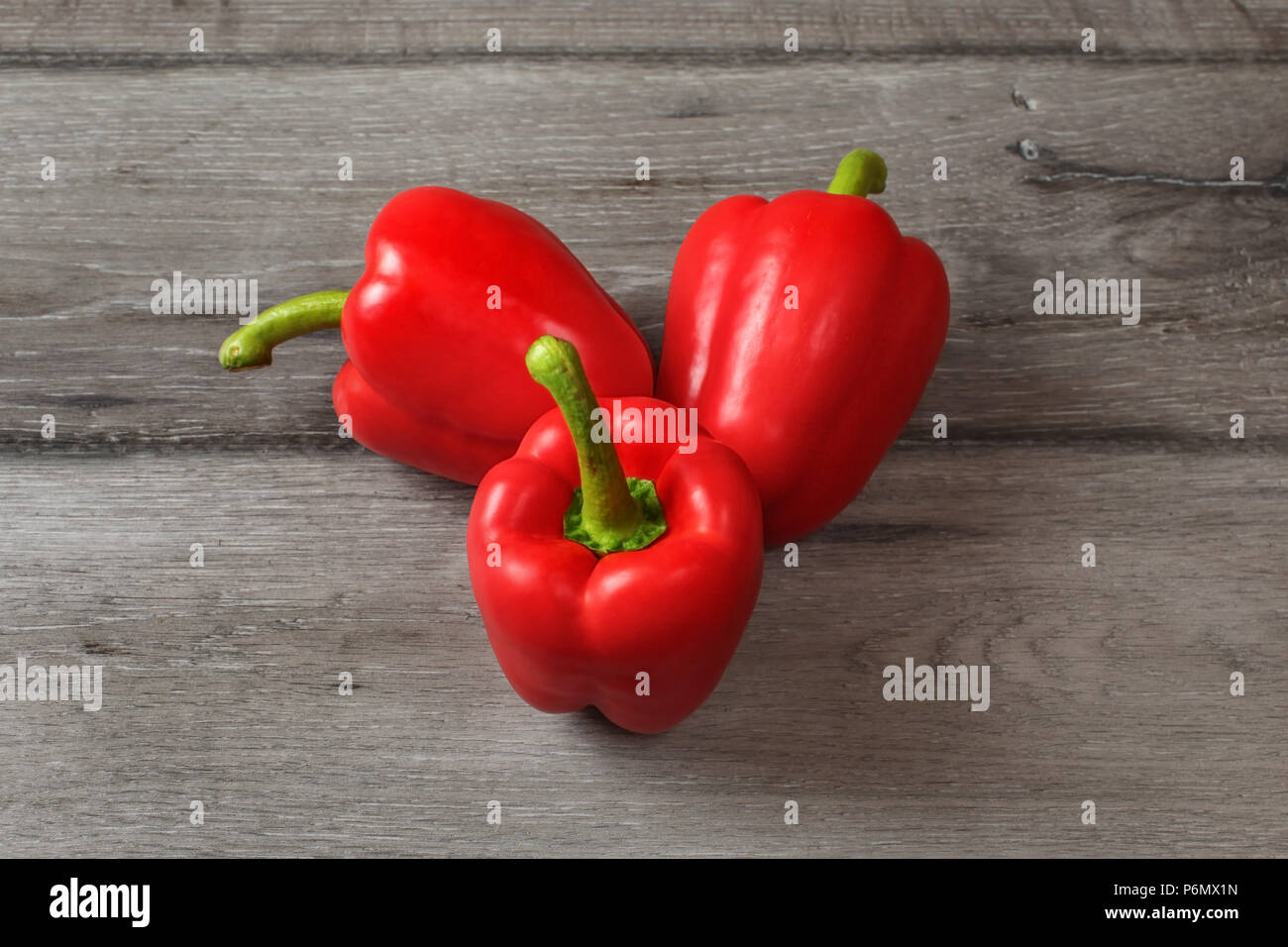 Table top view on three red bell peppers on a gray wood desk Stock ...