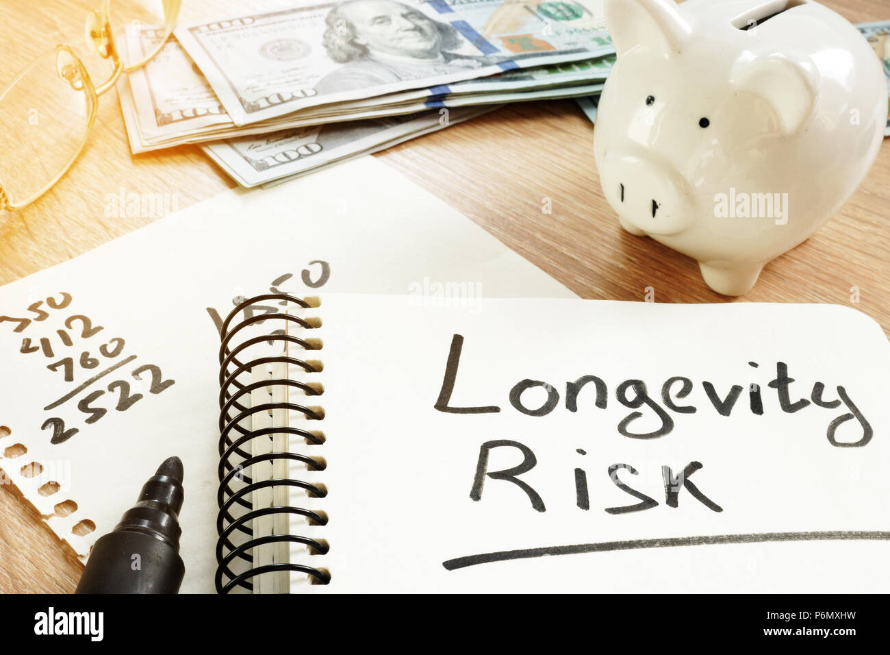 Longevity risk handwritten on a note. Pension concept. Stock Photo