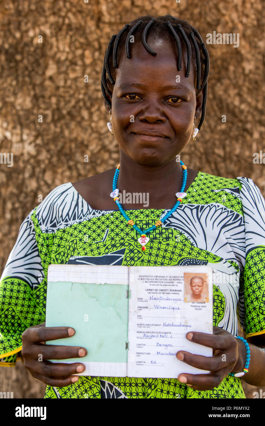 Member of a women's microfinance cooperative showing her savings book in Northern Togo. Stock Photo