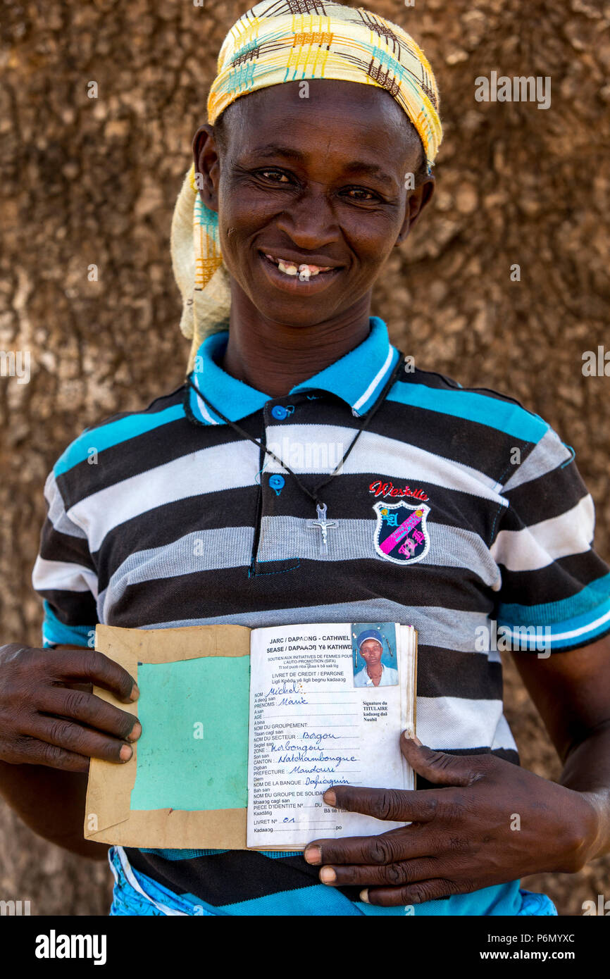 Member of a women's microfinance cooperative showing her savings book in Northern Togo. Stock Photo