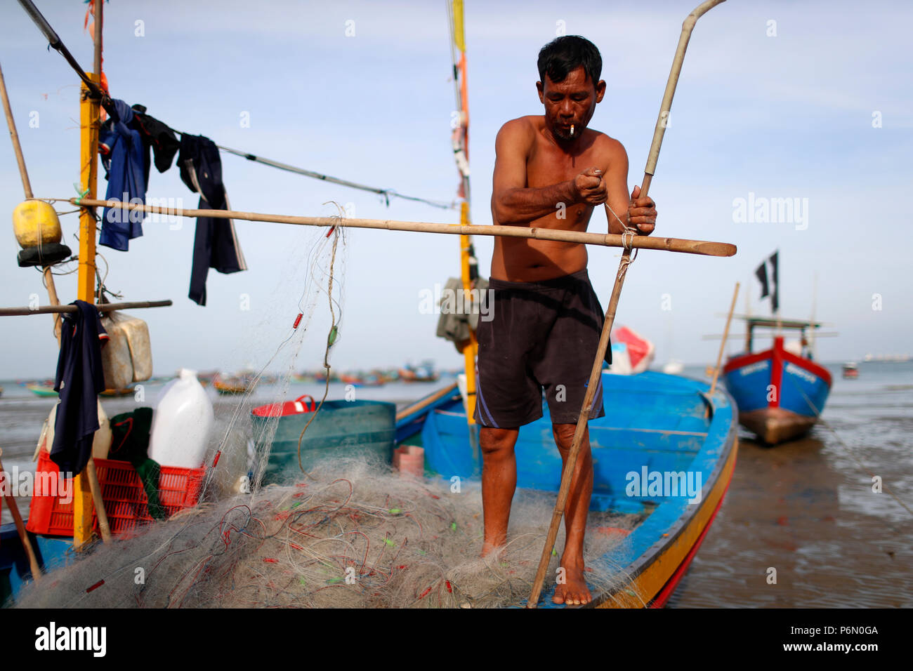 Fishermen repairing fishing nets. Hang Dua bay.  Vung Tau. Vietnam. Stock Photo