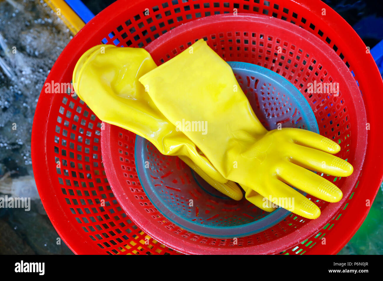 Fish market.  Yellow rubber gloves  in red basket.  Vung Tau. Vietnam. Stock Photo
