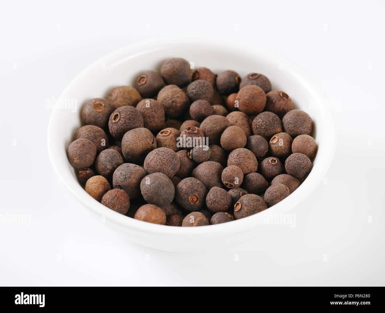bowl of allspice berries on white background Stock Photo Alamy