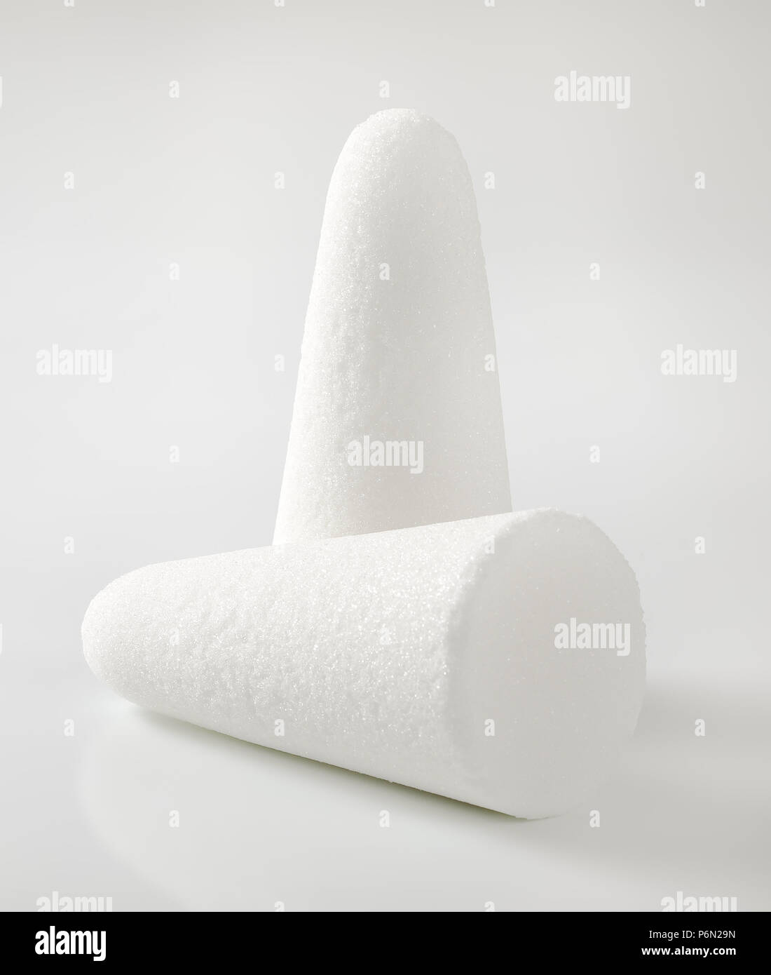 two white sugar loaves or cones on white background Stock Photo