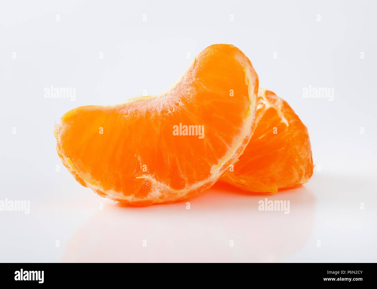 two slices of fresh tangerine on white background Stock Photo