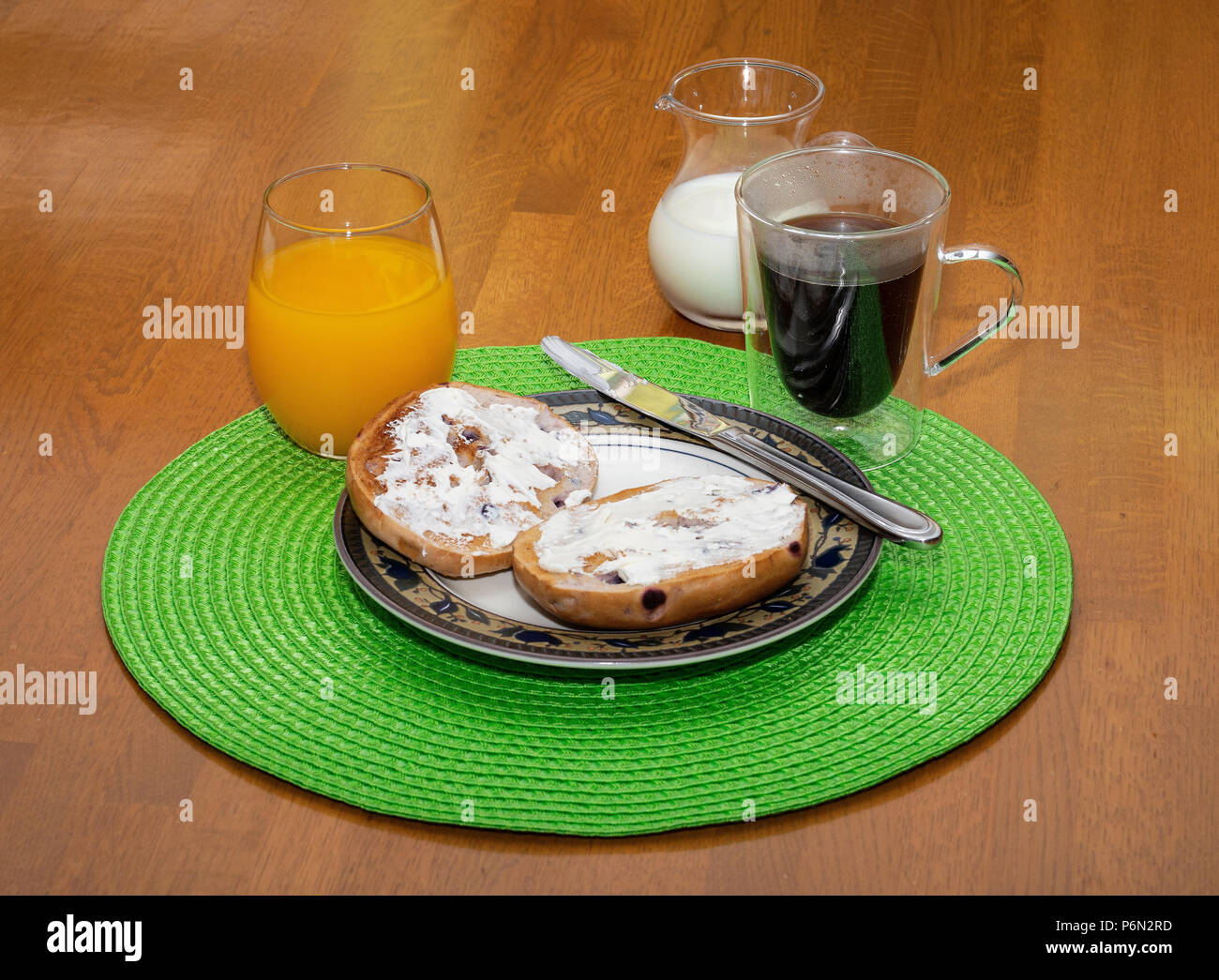 Toasted blueberry bagel breakfast with coffee and orange juice Stock